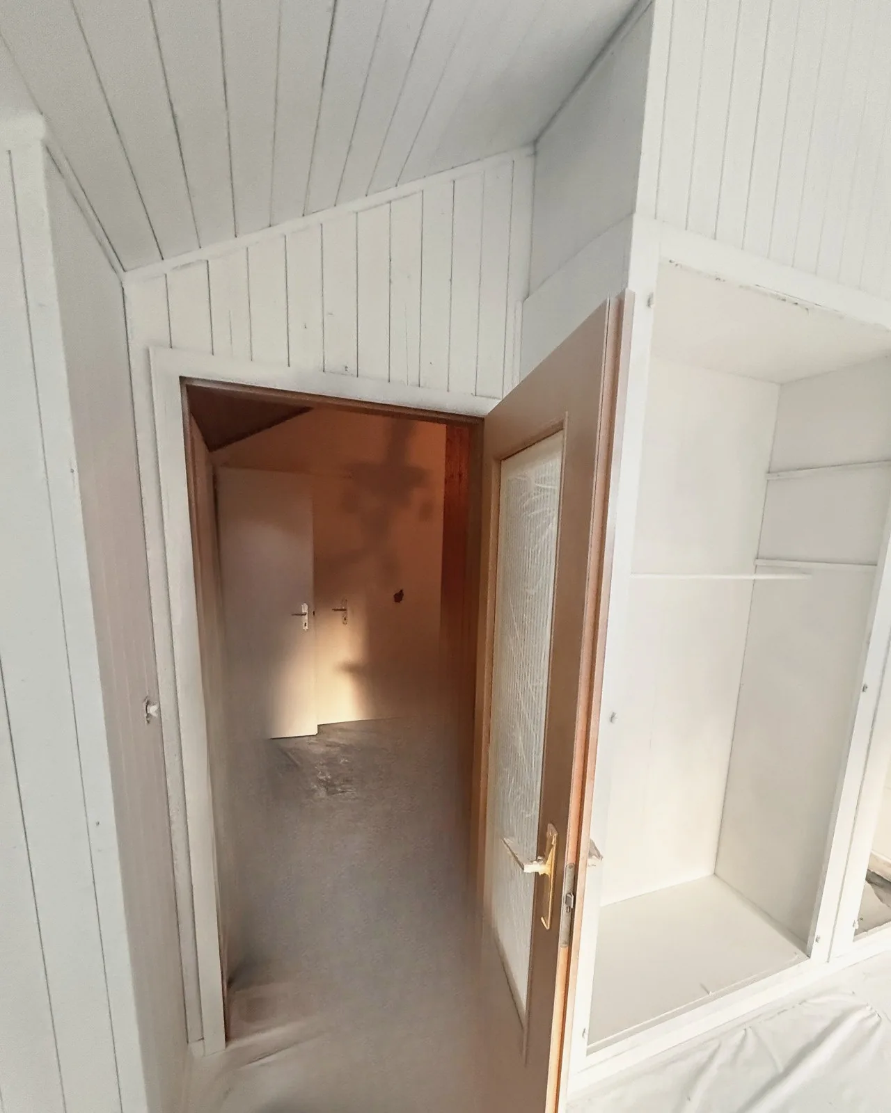 Lambris et encadrement de porte peints en blanc, après les travaux